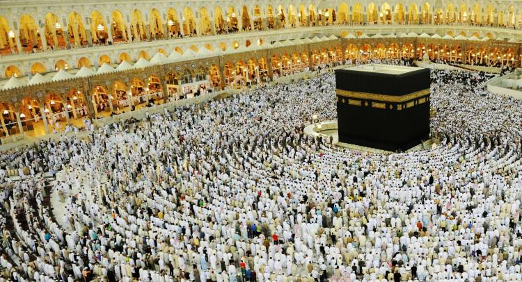Muslim worshippers standing in prayer towards the Ka'bah from all directions.